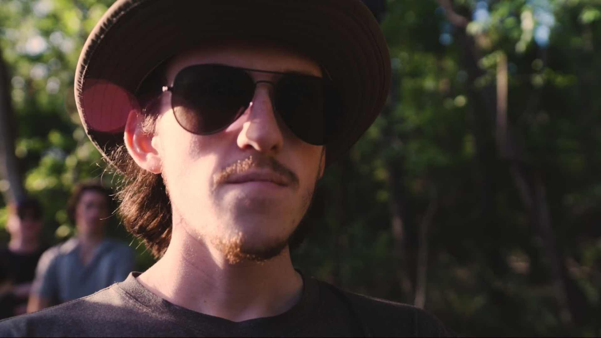 A director-liked character with shades on and a stern look to his face